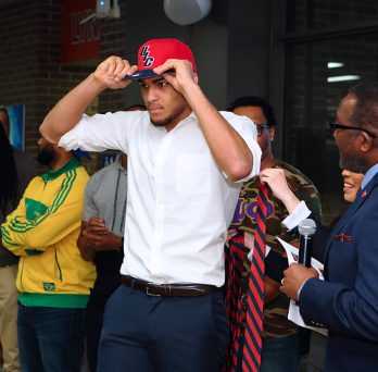 Reon Gillespie tries on his new UIC hat given by UIC Dean Alfred Tatum.
                  